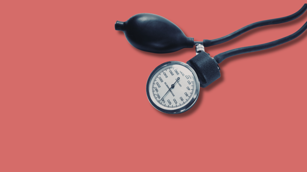 sfigmomanometro per misurare la pressione su sfondo rosa uniforme